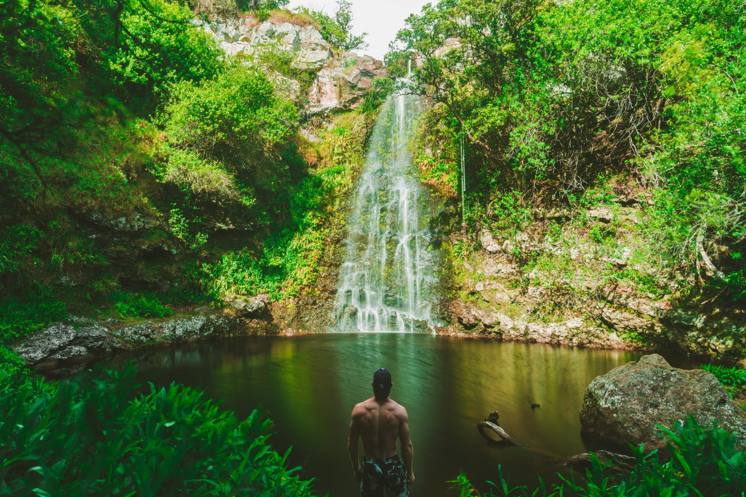 Man Adoring waterfall and a small lake